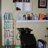 Shampoo sink and chair next to hair products available for purchase
